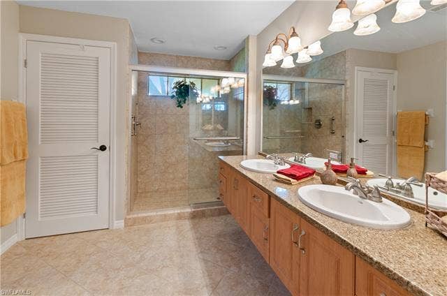 13201 Bridgeford Ave, Bonita Springs, FL 34135 Large primary bathroom with large closet, walk in shower and double sinks