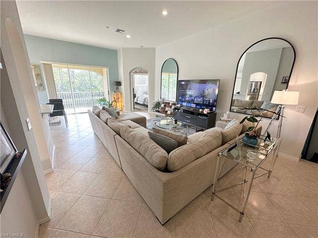 23007 Lone Oak Dr, Estero, FL 33928 Living room with arched walkways, light tile patterned floors, healthy amount of natural light, and recessed lighting