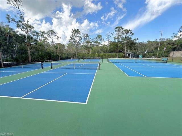 23007 Lone Oak Dr, Estero, FL 33928 View of tennis court featuring community basketball court and view of wooded area