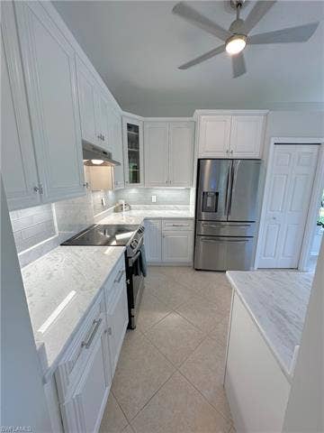 23007 Lone Oak Dr, Estero, FL 33928 Kitchen with stainless steel appliances, glass insert cabinets, white cabinetry, light stone counters, and under cabinet range hood