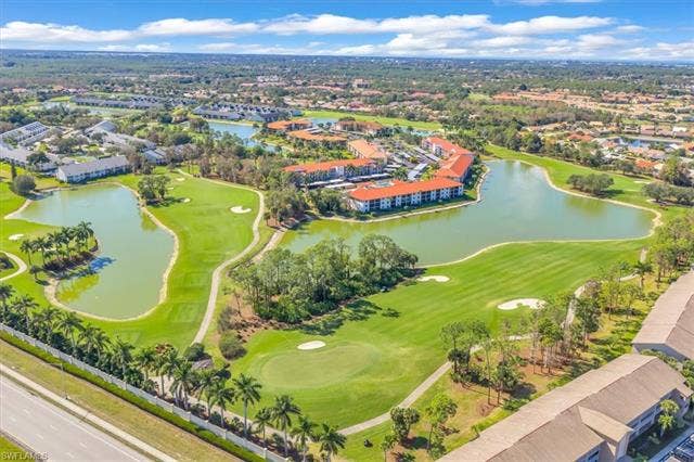 7320 Glenmoor Ln, #2304, Naples, FL 34104 Drone / aerial view of a local golf course and a nearby body of water