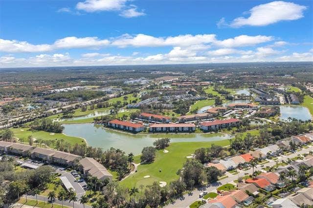 7320 Glenmoor Ln, #2304, Naples, FL 34104 Aerial view of property's location featuring a local golf course, a large body of water, and nearby suburban area