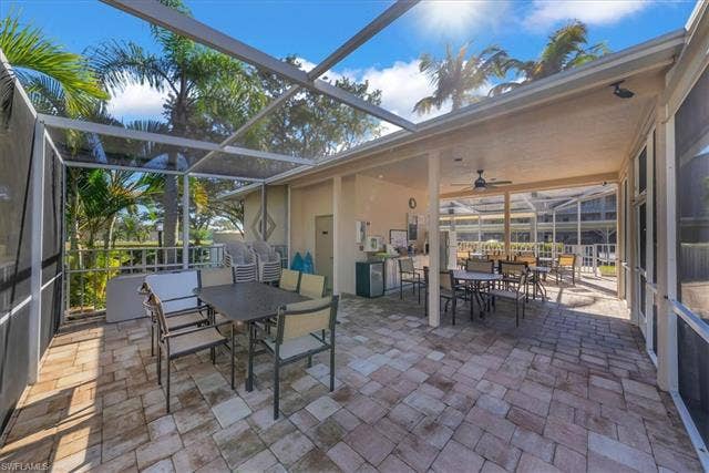 7320 Glenmoor Ln, #2304, Naples, FL 34104 View of patio featuring outdoor dining area, a sunroom, glass enclosure, and ceiling fan