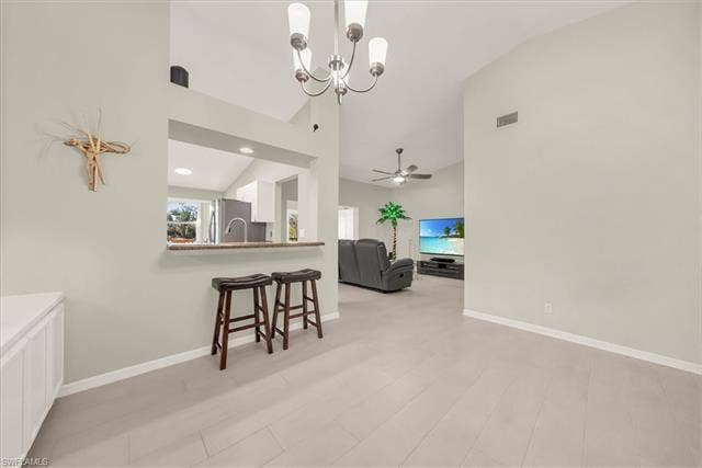 7320 Glenmoor Ln, #2304, Naples, FL 34104 Dining area featuring a chandelier, high vaulted ceiling, light wood finished floors, and ceiling fan