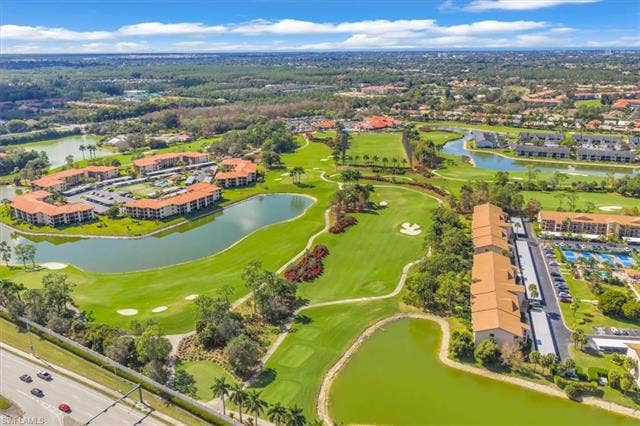 7320 Glenmoor Ln, #2304, Naples, FL 34104 Drone / aerial view of a golf course and a large body of water