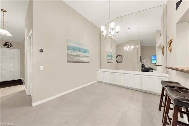 7320 Glenmoor Ln, #2304, Naples, FL 34104 Bathroom featuring lofted ceiling, double vanity, and a chandelier