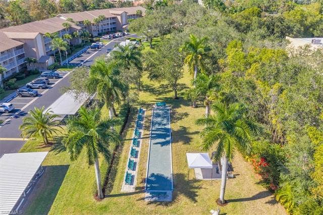 7320 Glenmoor Ln, #2304, Naples, FL 34104 Drone / aerial view of apartment complex / building and a tree filled landscape