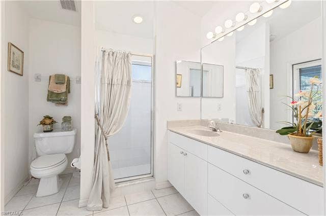 3650 Sunland Ln, Estero, FL 33928 Full bathroom with a shower stall, vanity, and light tile patterned flooring