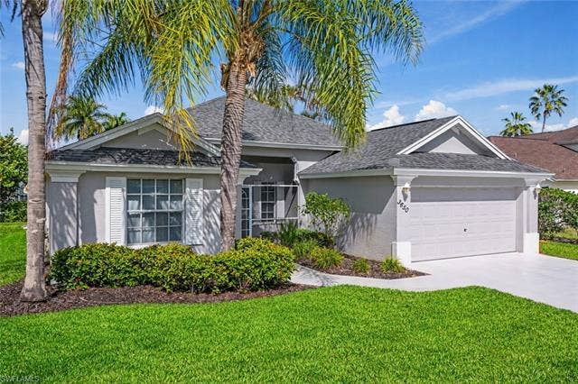 3650 Sunland Ln, Estero, FL 33928 Ranch-style home featuring a front lawn, an attached garage, concrete driveway, and stucco siding