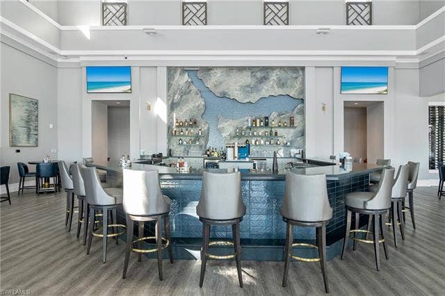 18500 Wildblue Blvd, Fort Myers, FL 33928 Bar with dark countertops, a high ceiling, and open shelves