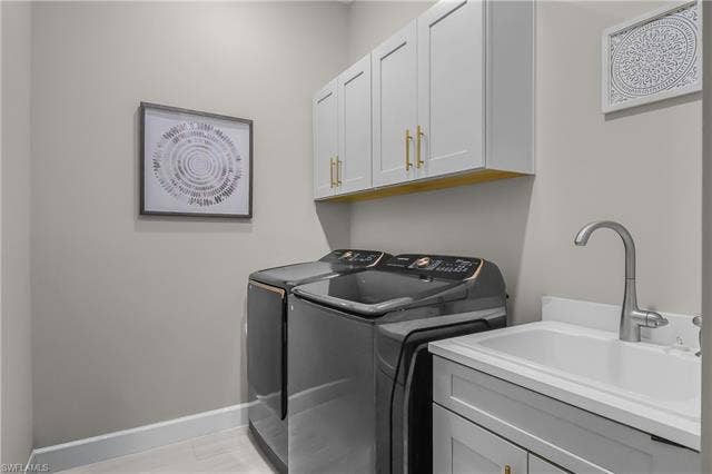 18500 Wildblue Blvd, Fort Myers, FL 33928 Laundry area with washing machine and dryer and cabinet space