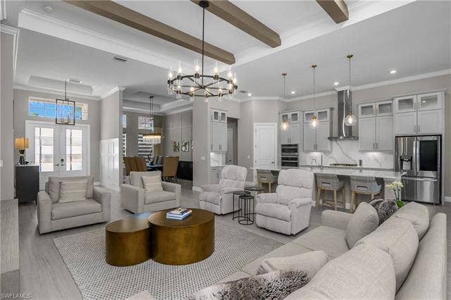 18500 Wildblue Blvd, Fort Myers, FL 33928 Living room featuring crown molding, hanging lights, wood finished floors, french doors, and a raised ceiling