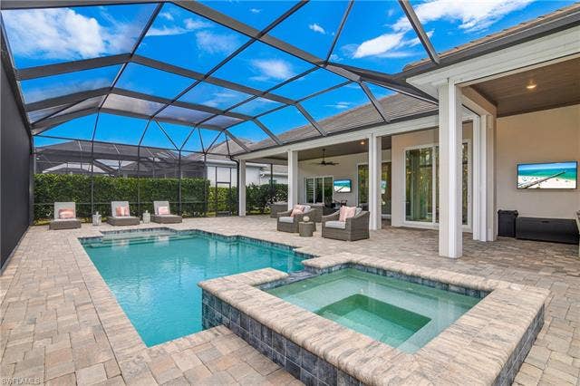 18500 Wildblue Blvd, Fort Myers, FL 33928 Integrated pool / spa with a patio area, a sunroom, a lanai, and outdoor lounge area