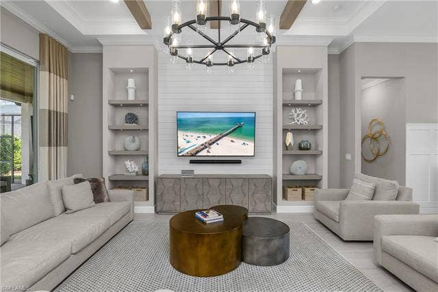 18500 Wildblue Blvd, Fort Myers, FL 33928 Living room with built in features, crown molding, beam ceiling, hanging lights, and wood finished floors