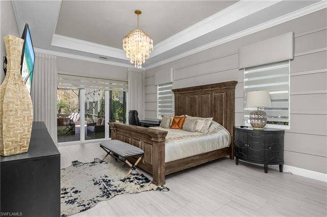 18500 Wildblue Blvd, Fort Myers, FL 33928 Bedroom featuring access to exterior, suspended lighting, a tray ceiling, and ornamental molding
