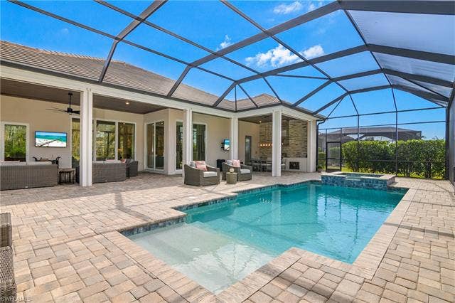 18500 Wildblue Blvd, Fort Myers, FL 33928 Combined pool / hot tub featuring outdoor seating, a sunroom, a lanai, and a patio area