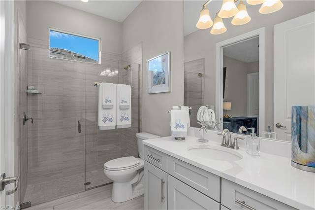 18500 Wildblue Blvd, Fort Myers, FL 33928 Full bathroom featuring vanity, a stall shower, and hanging lights