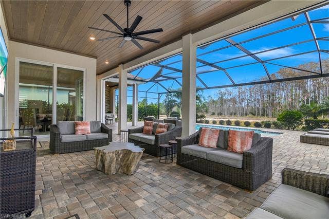 18500 Wildblue Blvd, Fort Myers, FL 33928 View of patio / terrace featuring outdoor seating, a sunroom, an outdoor pool, a lanai, and ceiling fan