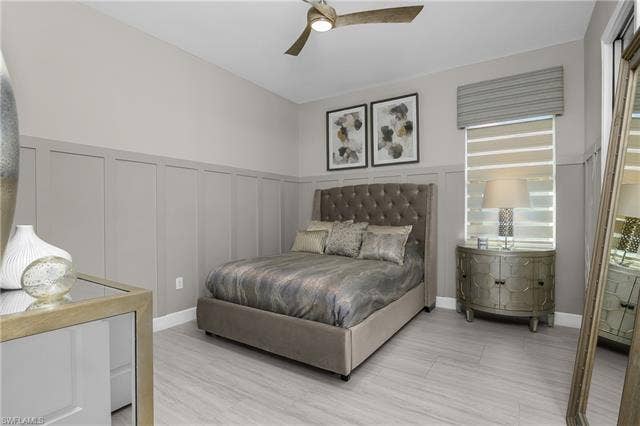 18500 Wildblue Blvd, Fort Myers, FL 33928 Bedroom featuring a decorative wall, a wainscoted wall, and ceiling fan