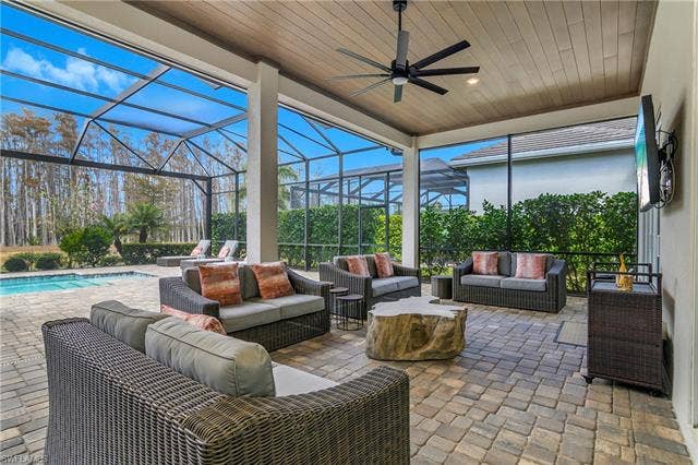 18500 Wildblue Blvd, Fort Myers, FL 33928 View of patio with outdoor lounge area, a sunroom, a lanai, ceiling fan, and an outdoor pool