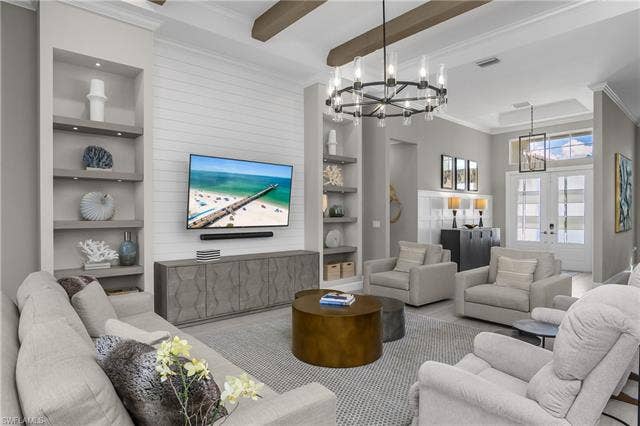 18500 Wildblue Blvd, Fort Myers, FL 33928 Living room featuring built in shelves, crown molding, beamed ceiling, suspended lighting, and wood finished floors