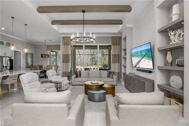 18500 Wildblue Blvd, Fort Myers, FL 33928 Living area with suspended lighting, ornamental molding, built in shelves, wood finished floors, and beamed ceiling