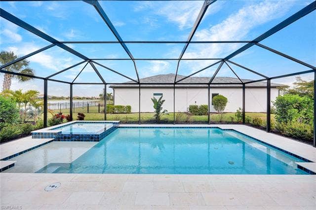 18298 Ridgeline Dr, Estero, FL 33928 Combined pool / hot tub with a sunroom, a patio, a lanai, and a yard