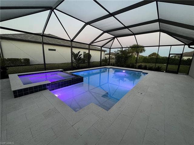 18298 Ridgeline Dr, Estero, FL 33928 Integrated pool / hot tub featuring a sunroom, a lanai, and a patio area
