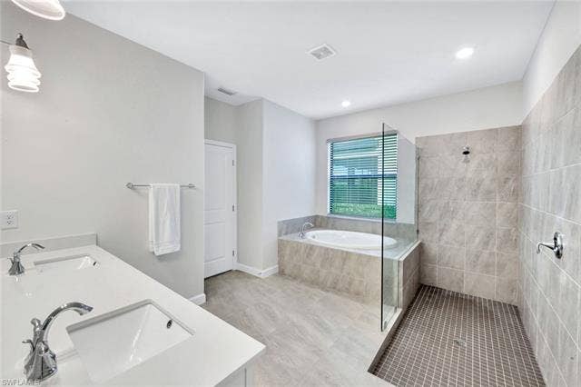18298 Ridgeline Dr, Estero, FL 33928 Full bath with double vanity, a walk in shower, a garden tub, light tile patterned flooring, and recessed lighting