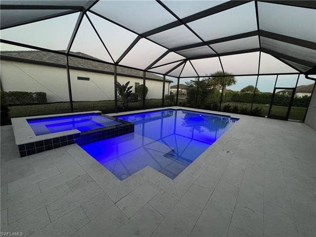 18298 Ridgeline Dr, Estero, FL 33928 Combined pool / hot tub with a sunroom, a lanai, and a patio area