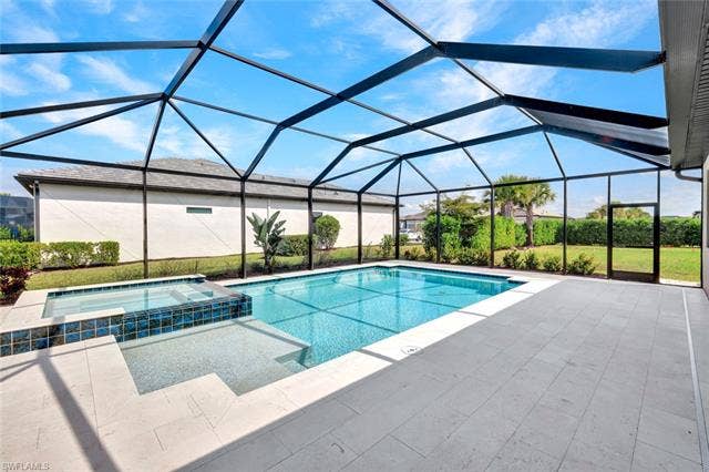 18298 Ridgeline Dr, Estero, FL 33928 Integrated pool / hot tub with a sunroom, a lanai, and a patio
