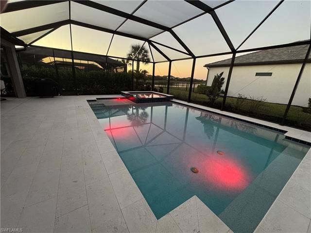 18298 Ridgeline Dr, Estero, FL 33928 Integrated pool / hot tub with a lanai, a sunroom, and a patio