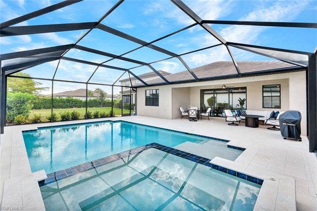18298 Ridgeline Dr, Estero, FL 33928 Relaxing pool / spa with outdoor lounge area, a sunroom, and a lanai