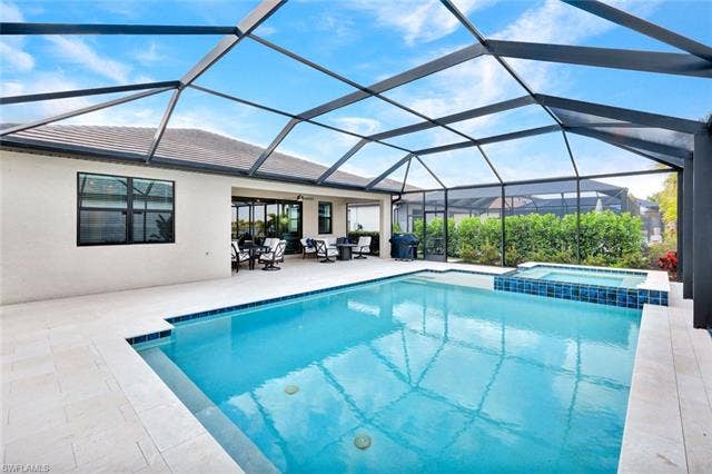 18298 Ridgeline Dr, Estero, FL 33928 Relaxing pool / spa with a sunroom, glass enclosure, and a patio