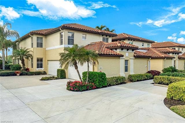 20667 Wildcat Run Dr, #101, Estero, FL 33928 Mediterranean / spanish house with stucco siding, driveway, and an attached garage