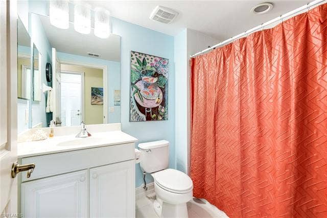 20667 Wildcat Run Dr, #101, Estero, FL 33928 Guest Full bathroom featuring vanity, light tile patterned floors, and shower / tub combo with curtain