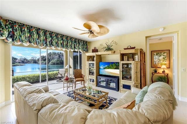 20667 Wildcat Run Dr, #101, Estero, FL 33928 Tiled living room featuring a ceiling fan and a water view