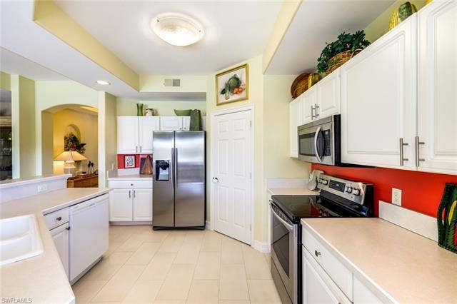 20667 Wildcat Run Dr, #101, Estero, FL 33928 Kitchen with stainless steel appliances, white cabinetry, light countertops, and recessed lighting