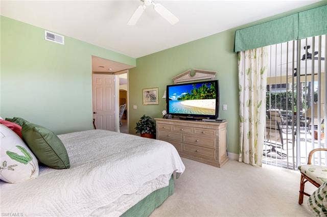 20667 Wildcat Run Dr, #101, Estero, FL 33928 Primary Bedroom with access to outside, carpet, and a ceiling fan