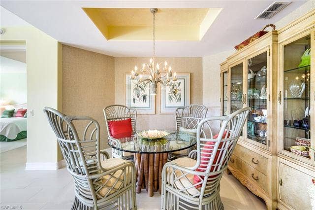 20667 Wildcat Run Dr, #101, Estero, FL 33928 Dining space featuring a raised ceiling, hanging lights, and light tile patterned floors