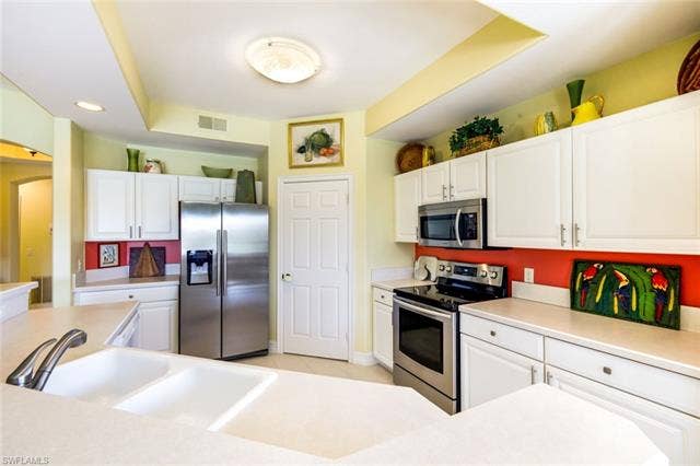20667 Wildcat Run Dr, #101, Estero, FL 33928 Kitchen featuring stainless steel appliances, white cabinetry, light countertops, and recessed lighting