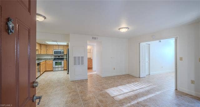 3160 Seasons Way, #709, Estero, FL 33928 Kitchen with stainless steel appliances, light tile patterned floors, and light countertops