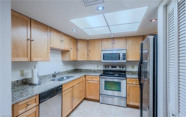 3160 Seasons Way, #709, Estero, FL 33928 Kitchen with stainless steel appliances, light stone countertops, light tile patterned floors, recessed lighting, and light wood finish cabinetry