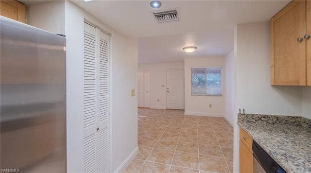 3160 Seasons Way, #709, Estero, FL 33928 Kitchen featuring stainless steel appliances, light wood finish cabinetry, light stone counters, and light tile patterned floors