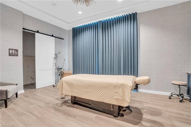 11861 Venetian Lagoon Dr, #203, Fort Myers, FL 33913 Bedroom featuring wood finish floors and a barn door