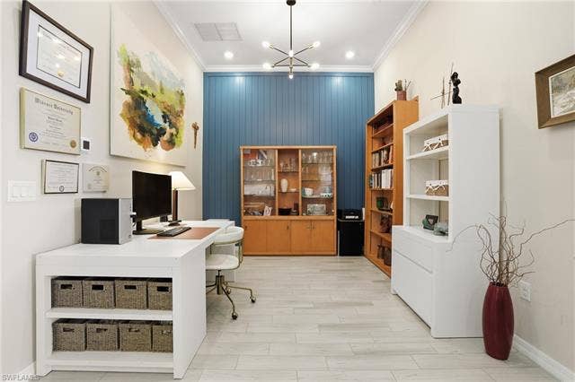 11861 Venetian Lagoon Dr, #203, Fort Myers, FL 33913 Office space featuring hanging lights, crown molding, wood finish floors, and an accent wall