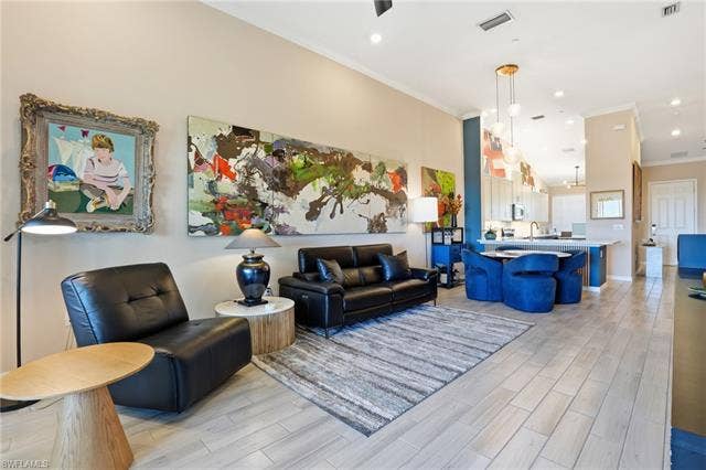 11861 Venetian Lagoon Dr, #203, Fort Myers, FL 33913 Living area featuring wood tiled floors, ornamental molding, recessed lighting, and a high ceiling