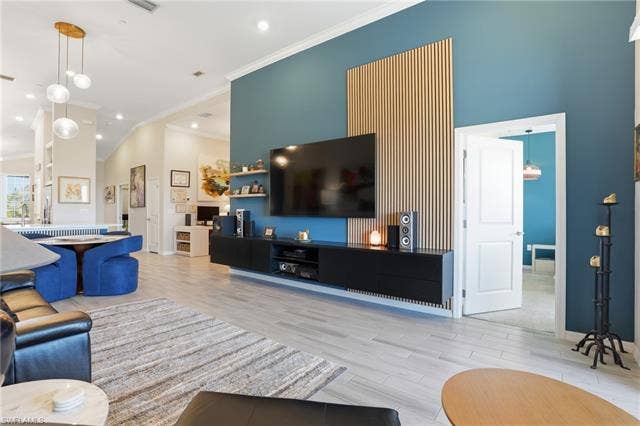11861 Venetian Lagoon Dr, #203, Fort Myers, FL 33913 Living area featuring light wood-style flooring, ornamental molding, and lofted ceiling