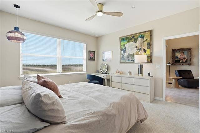 11861 Venetian Lagoon Dr, #203, Fort Myers, FL 33913 Bedroom featuring light carpet and a ceiling fan