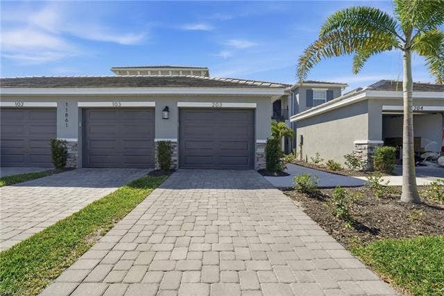 11861 Venetian Lagoon Dr, #203, Fort Myers, FL 33913 Prairie-style home with stone siding, stucco siding, and decorative driveway
